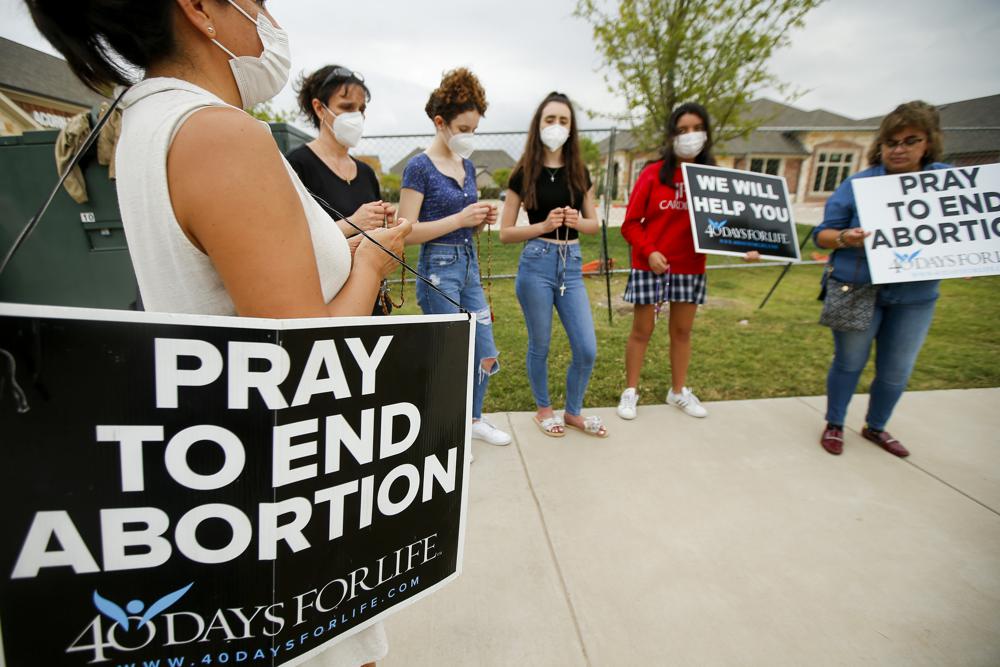 Anti-abortion demonstrators pray and protest outside of a Whole Women's Health of North Texas, Friday, Oct. 1, 2021, in McKinney, Texas. A federal judge did not say when he would rule following a nearly three-hour hearing in Austin during which abortion providers sought to block the nation's most restrictive abortion law, which has banned most abortions in Texas since early September. (AP Photo/Brandon Wade)