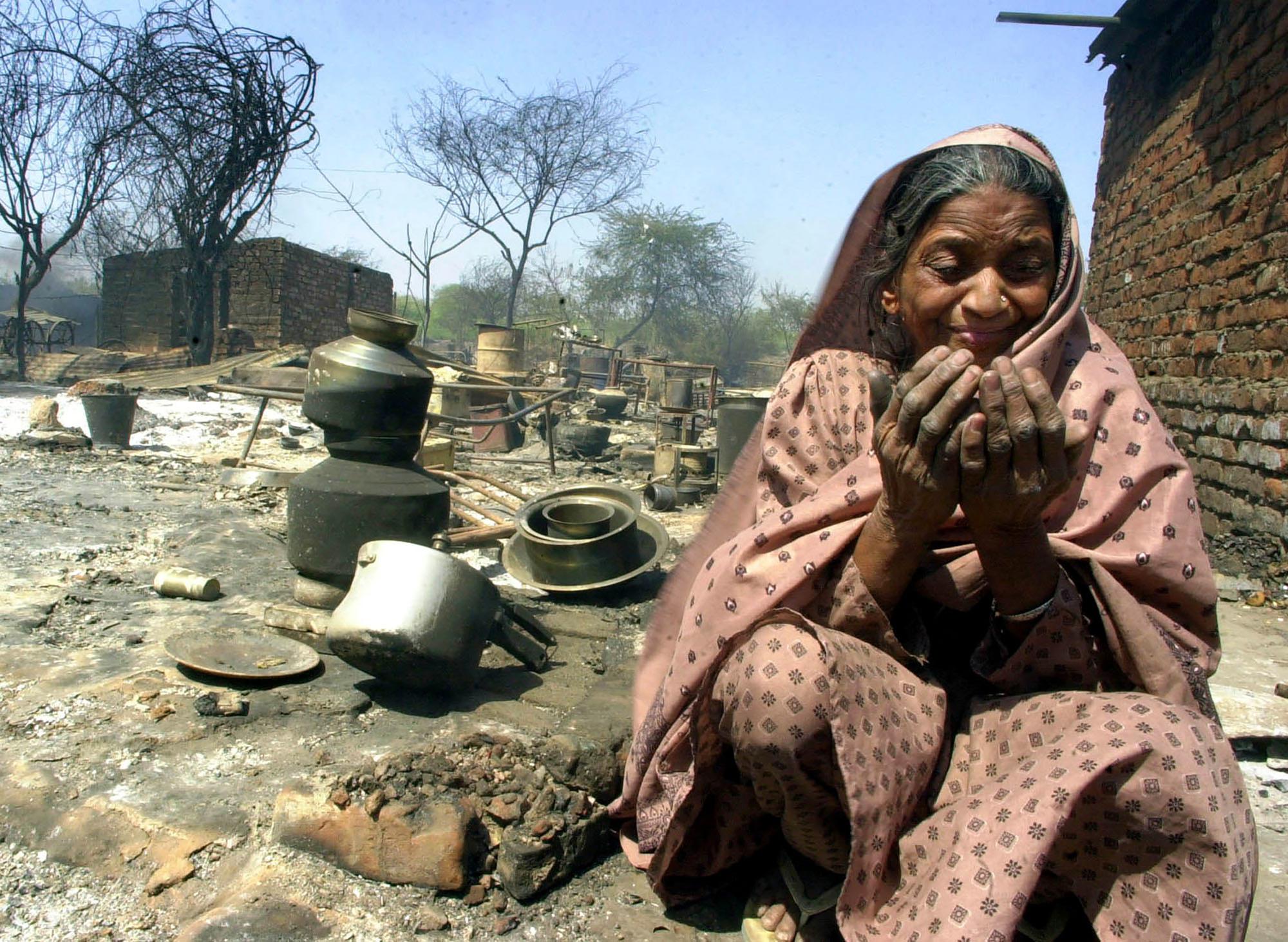 FILE - Razia, a Muslim woman, cries while praying by her destroyed home near Ahmedabad, India, March 2, 2002. Vengeful Hindu mobs torched Muslim homes, killing scores, as rioting spread through western Gujarat state leading to the death of at least 1,000 in one of India's worst religious strife. (AP Photo/Aman Sharma, File)
