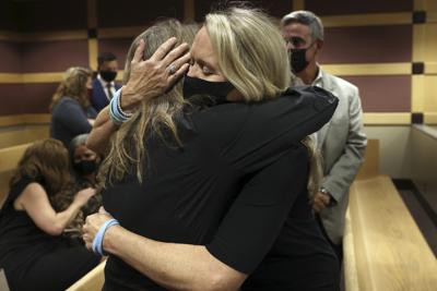 Gena Hoyer, right, hugs Debbie Hixon during a court recess following Marjory Stoneman Douglas High School shooter Nikolas Cruz's guilty plea on all 17 counts of premeditated murder and 17 counts of attempted murder in the 2018 shootings, Wednesday, Oct. 20, 2021, at the Broward County Courthouse in Fort Lauderdale, Fla. Hoyer's son, Luke Hoyer, 15, and Hixon's husband, Christopher Hixon, 49, were both killed in the massacre. (Amy Beth Bennett/South Florida Sun Sentinel via AP, Pool)