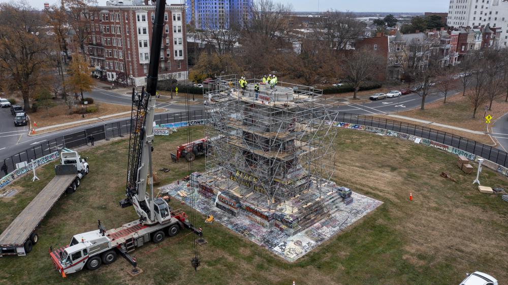 Workers begin the disassembly of the pedestal that once held the statue of Confederate General Robert E. Lee on Monument Avenue Wednesday Dec 8, 2021, in Richmond, Va. Virginia Gov. Ralph Northam ordered the pedestal removed and the land granted to the City of Richmond. (AP Photo/Steve Helber)