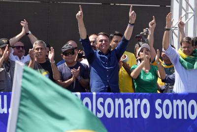 El presidente de Brasil, Jair Bolsonaro, agradece a sus simpatizantes, junto a su esposa, Michelle de Paula Firmo Reinaldo Bolsonaro, durante un mitin por el Día de la Independencia en Brasilia, el martes 7 de septiembre de 2021. (AP Foto/Eraldo Peres)