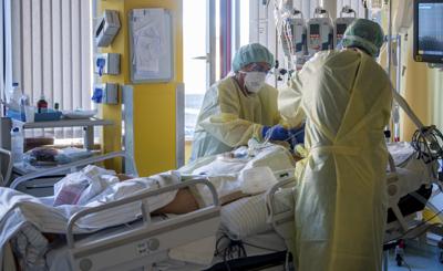 Enfermeras de la unidad de cuidados intensivos tratan a un paciente grave de COVID-19 en la UCI del hospital universitario en Halle/Saale, Alemania, el 22 de noviembre de 2021. (Hendrik Schmidt/dpa vía AP)