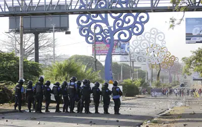 ARCHIVO - Policías y manifestantes se enfrentan en Managua, Nicaragua, 20 de abril de 2018. Una investigación divulgada el 28 de abril de 2023 por el Colectivo de Derechos Humanos "Nicaragua Nunca Más" reportó que al menos 158 personas detenidas en Nicaragua desde las protestas de 2018 sufrió torturas y la mayoría fueron víctimas de violencia sexual por parte de funcionarios penitenciarios y altos mandos policiales. (AP Foto/Alfredo Zuniga, Archivo)