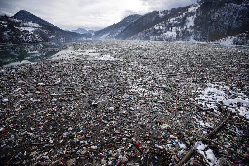 FILE - In this Friday, Jan. 22, 2021 file photo, plastic bottles and other garbage floats in the Potpecko lake near Priboj, in southwest Serbia. An intergovernmental conference has taken early steps toward drawing up an agreement to curb plastic pollution and marine litter around the world, which can choke off sea life, harm food safety and coastal tourism, and contribute to climate change. A draft resolution presented by Peru and Rwanda, and backed by the European Union and several other countries, amounts to a procedural step. (AP Photo/Darko Vojinovic, File)