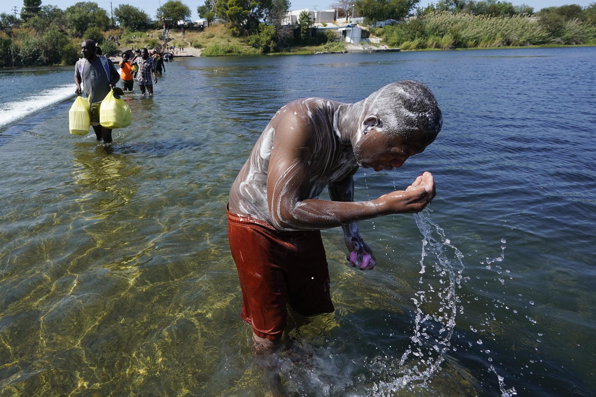 FILE - A Haitian migrant uses the Rio Grande to take a bath after crossing a dam from Mexico to the United States, Sept. 17, 2021, in Del Rio, Texas. The Border Patrol encountered migrants in South Texas more often than ever in June and July, dashing expectations for a common summer slowdown. In September, about 15,000 mostly Haitian refugees were camped under a bridge in the small border town of Del Rio, Texas. (AP Photo/Eric Gay, File)