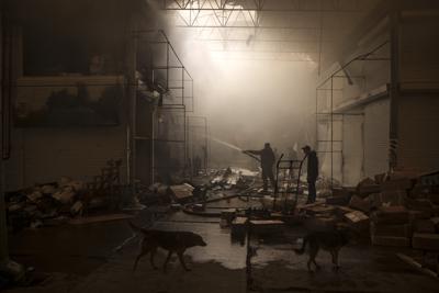 Varias personas intentan extinguir un incendio en un mercado tras un ataque ruso, en Járkiv, Ucrania, el 25 de marzo de 2022. (AP Foto/Felipe Dana)