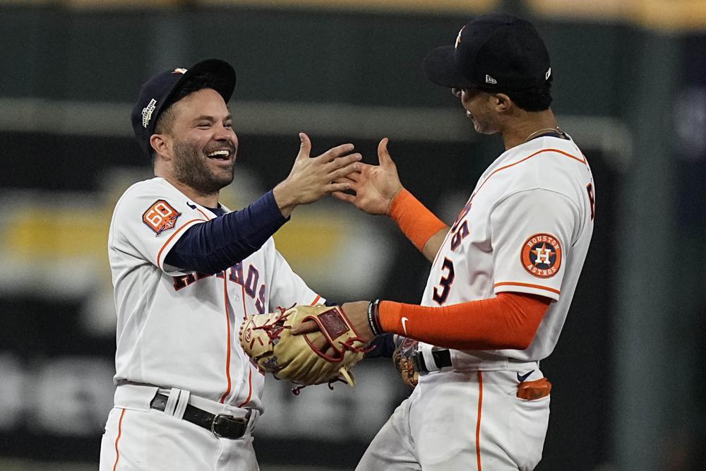 El venezolano José Altuve y el dominicano Jeremy Peña festejan la victoria de los Astros en el primer juego de la Serie de Campeonato de la Liga Americana, ante los Yanquis de Nueva York, el miércoles 19 de octubre de 2022 (AP Foto/Kevin M. Cox)