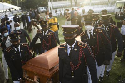 Policías cargan el féretro con los restos del presidente haitiano Jovenel Moïse al inicio del funeral el viernes 23 de julio de 2021, en su finca familiar en Cabo Haitiano, Haití. (AP Foto/Matías Delacroix)