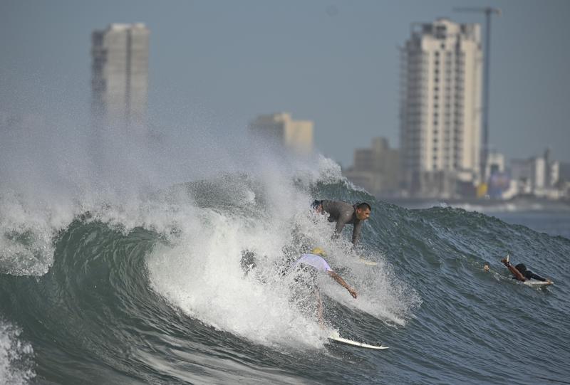 Varias personas hacen surf en la playa de Pinitos antes de la llegada de la tormenta tropical Pamela, en Mazatlán, México, el 12 de octubre de 2021. (AP Foto/Roberto Echeagaray)