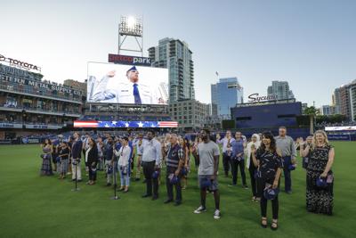 Decenas de personas juran fidelidad a la bandera de EEUU tras recibir la ciudadanía en una ceremonia realizada antes de un juego de béisbol en San Diego el 26 de agosto del 2019. (AP Photo/Gregory Bull,File)