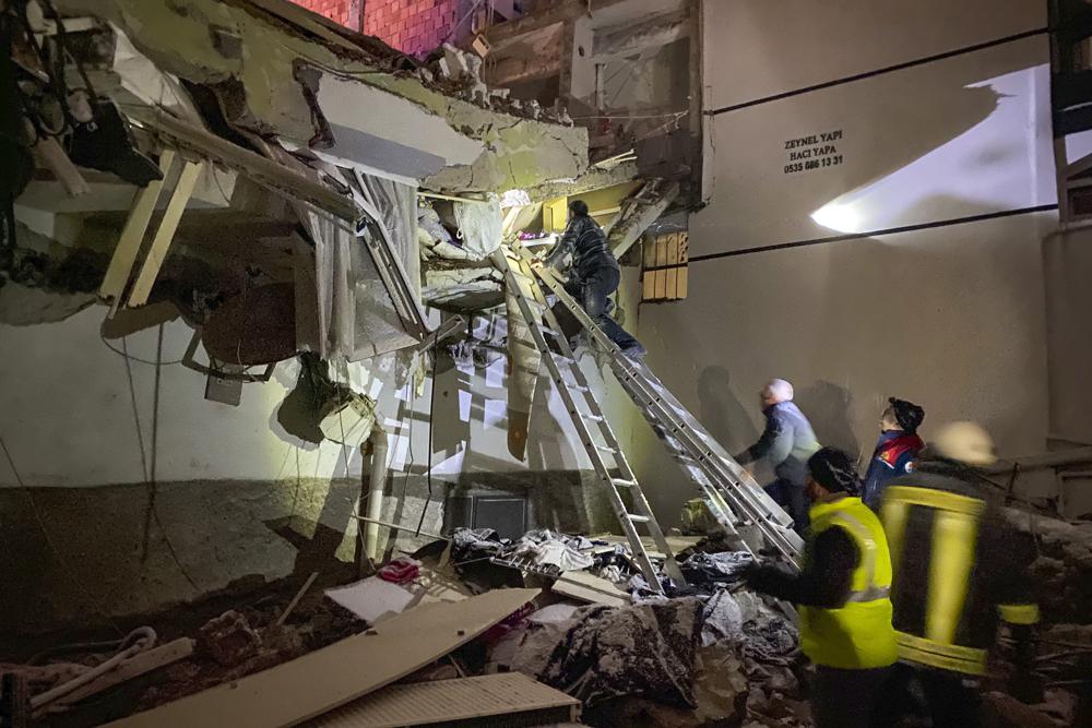 Rescue teams try to reach trapped residents inside collapsed buildings in Adana, Turkey, Monday, Feb. 6, 2023. A powerful quake has knocked down multiple buildings in southeast Turkey and Syria and many casualties are feared. (IHA agency via AP)