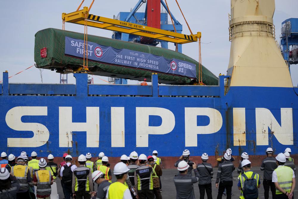 FILE - Workers use a crane to unload a Chinese-made high-speed passenger train car from a cargo ship at Tanjung Priok Port in Jakarta, Indonesia, Friday, Sept. 2, 2022, for the Jakarta-Bandung high-speed railway. A Chinese loan of $4 billion to help it build the railway never appeared on public government accounts. That all changed years later when, overbudget by $1.5 billion, the Indonesian government was forced to bail out the railroad twice. (AP Photo/Dita Alangkara, File)