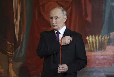 El presidente ruso Vladimir Putin hace la señal de la cruz durante un servicio de Pascua ortodoxo en la catedral de Cristo Salvador en Moscú, Rusia, el sábado 15 de abril de 2023. (Sergei Karpukhin, Sputnik, Kremlin Pool Photo vía AP)