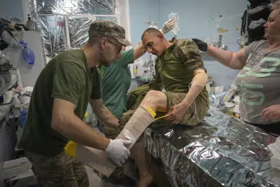 Médicos militares prestan primeros auxilios a soldados ucranianos en un centro de estabilización cerca de Bájmut, en la región de Donetsk, Ucrania, el miércoles 24 de mayo de 2023. (AP Foto/Efrem Lukatsky)