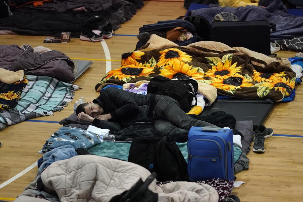 Refugiados ucranianos esperan en un gimnasio el martes 5 de abril de 2022 en Tijuana, México.  Cientos de refugiados ucranianos llegan diariamente a esta ciudad fronteriza mexicana, donde esperan de dos a cuatro días a que los funcionarios estadounidenses los admitan en libertad condicional humanitaria.  (Foto AP/Gregory Bull)