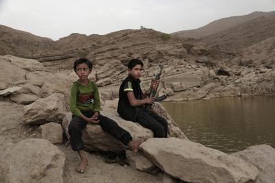 ARCHIVO - En esta foto de archivo del 30 de julio de 2018, un chico de 17 años sostiene su arma en la presa de Marib, Yemen. (AP Foto/Nariman El-Mofty)