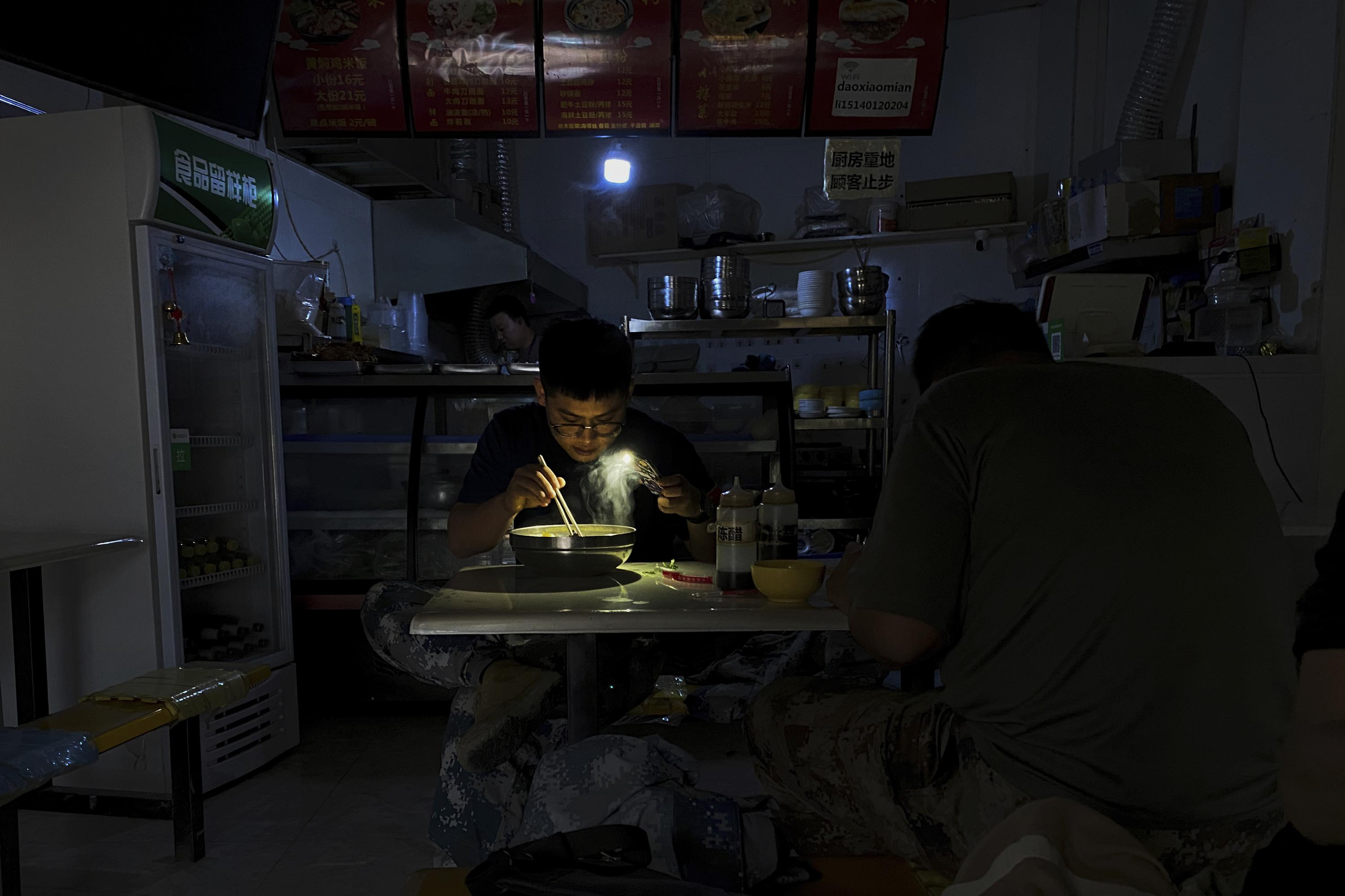 Chinese switch to flashlights, generators amid power cuts | AP News