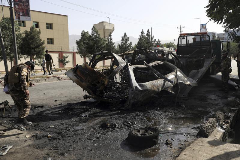 Afghan security personnel inspect the site of a bomb explosion in Kabul, Afghanistan, Saturday, June 12, 2021. Separate bombs hit two minivans in a mostly Shiite neighborhood in the Afghan capital Saturday, killing several people and wounding others, the Interior Ministry said. (AP Photo/Rahmat Gul)