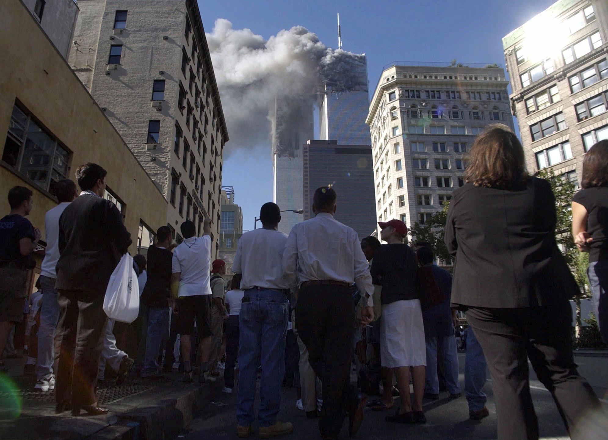 Pedestrians in lower Manhattan watch smoke billow from New York's World Trade Center on Tuesday, Sept. 11, 2001. (AP Photo/Amy Sancetta)