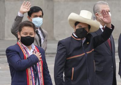 El presidente peruano Pedro Castillo, a la derecha, saluda junto al primer ministro Guido Bellido, a la izquierda, y los miembros de su gabinete en el palacio de gobierno mientras Bellido y el gabinete parten hacia el Congreso para pedirle a los legisladores un voto de confianza en Lima, Perú, el jueves 26 de agosto de 2021. (AP Foto/Martín Mejía)