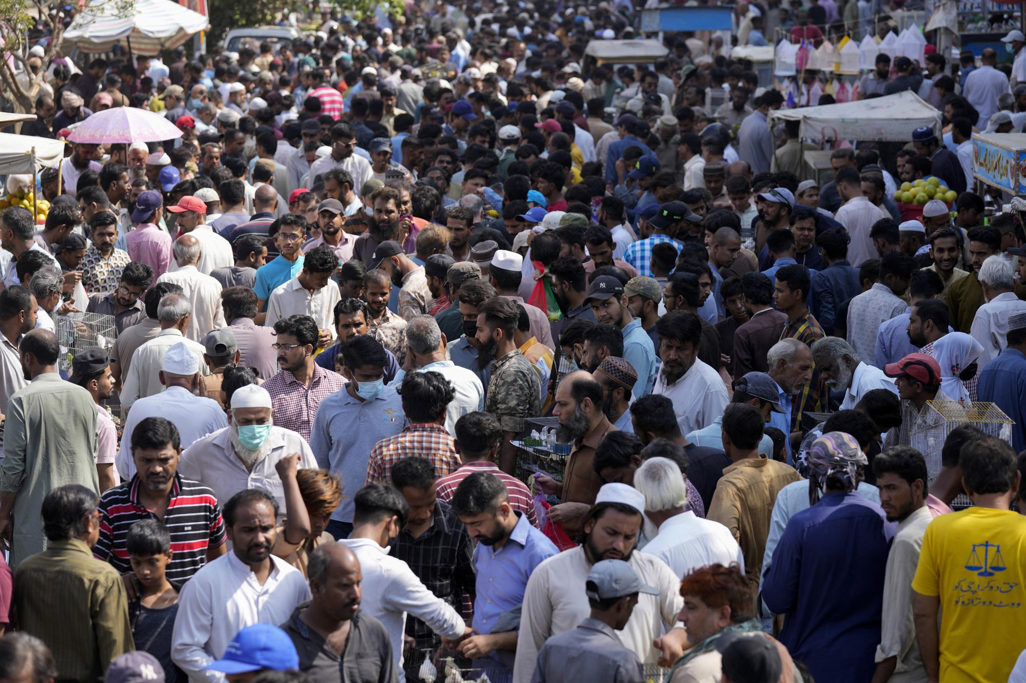 Pakistanis shops in a weekly pet market in Lahore, Pakistan, Monday, Nov. 13, 2022. The world's population is projected to hit an estimated 8 billion people on Tuesday, Nov. 15, according to a United Nations projection. (AP Photo/Fareed Khan)