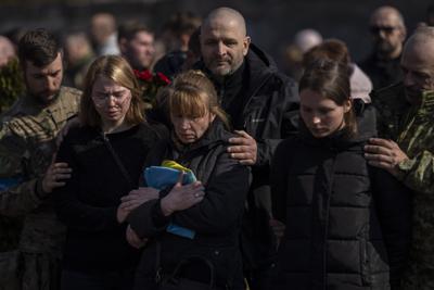 Familiares y amigos asisten al funeral del coronel ucraniano Oleg Yaschyshyn en Lviv, Ucrania, el martes 15 de marzo de 2022. Yaschyshyn murió durante el ataque con misiles rusos del domingo en una base de entrenamiento militar cerca de la frontera occidental de Ucrania con Polonia, miembro de la OTAN. (AP Foto/Bernat Armangue)