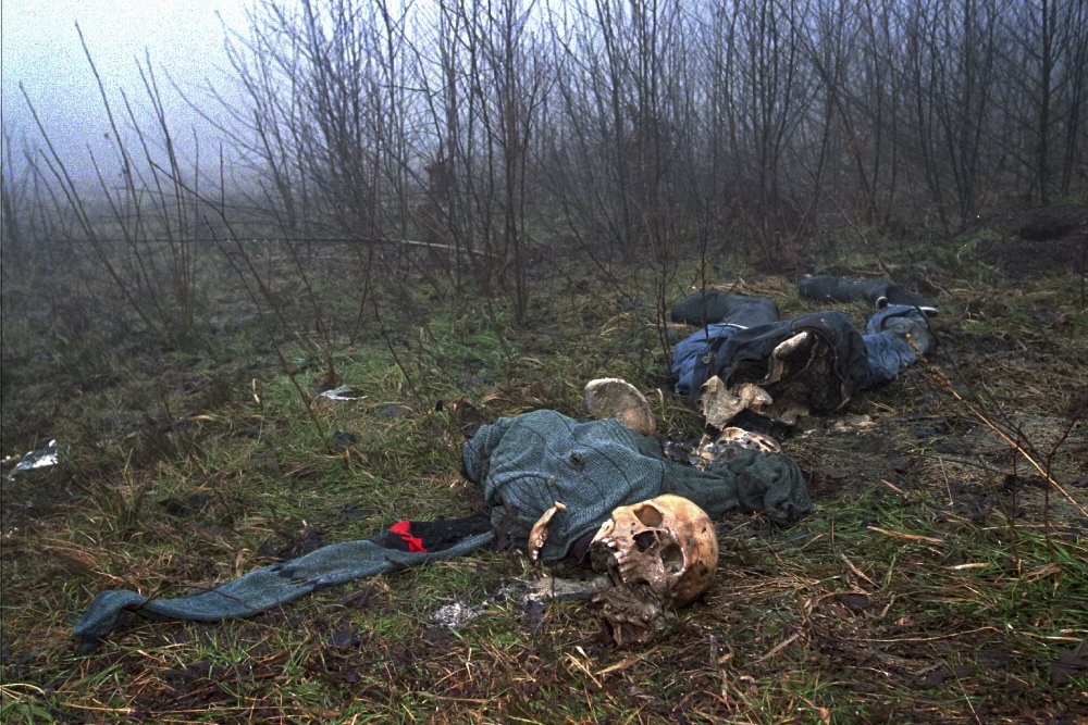 FILE- In this Sunday, Feb. 4, 1996, file photo one of four clothed skeletons examined by U.N. investigator Elizabeth Rehn, who is trying to trace an estimated 8,000 Muslim men missing after the Serb conquest of the former Muslim enclave of Srebrenica in July 1995, lies on a hilltop. More than 8,000 Muslim Bosniak men and boys perished 25 years ago during 10 days of slaughter after Srebrenica was overrun by Bosnian Serb forces on July 11, 1995, during Bosnia's 1992-95 war.  Survivors of the genocide in the eastern Bosnian town of Srebrenica, mainly women, will on Saturday July 11, 2020, commemorate the 25th anniversary of the slaughter of their fathers and brothers, husbands and sons.  At least 8,000 mostly Muslim men and boys were chased through woods in and around Srebrenica by Serb troops in what is considered the worst carnage of civilians in Europe since World War II. The slaughter was also the only atrocity of the brutal war that has been confirmed an act of genocide. (AP Photo/Alexander Zemlianichenko, File)