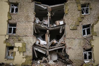 Los escombros cuelgan de un edificio residencial gravemente dañado en un bombardeo ruso en Bakhmut, este de Ucrania, este de Ucrania, el sábado 28 de mayo de 2022. Los combates se han desatado alrededor de Lysychansk y la vecina Sievierodonetsk, las últimas ciudades importantes bajo control ucraniano en la región de Lugansk. (AP Foto/Francisco Seco)