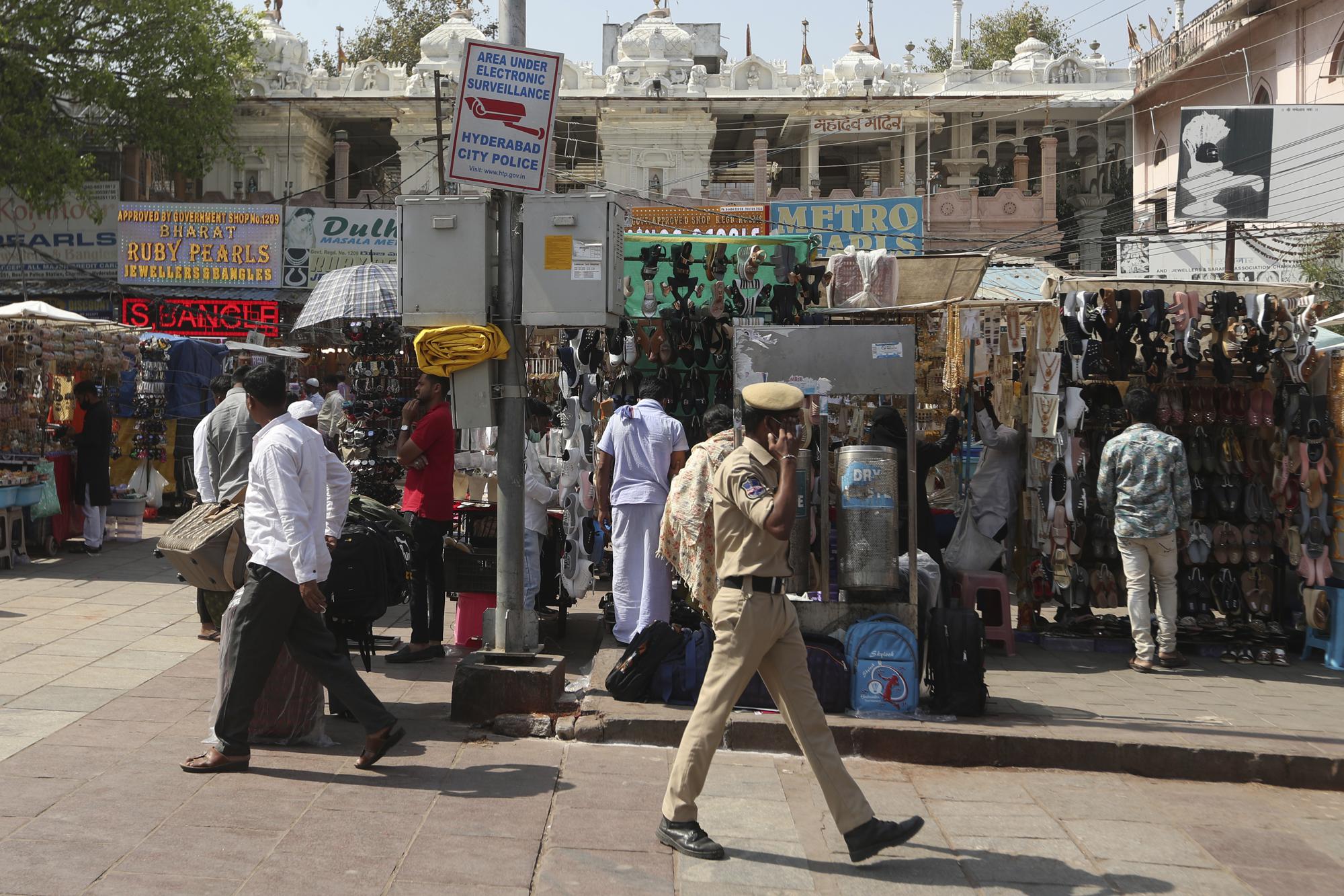 A sign warns passers-by that they are under surveillance near the landmark Charminar monument in Hyderabad, India, Friday, Jan. 28, 2022. (AP Photo/Mahesh Kumar A.)