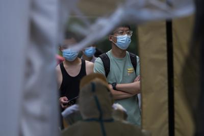 Vecinos esperando para hacerse pruebas en COVID-19 en un centro de pruebas en el distrito de Chaoyang en Beijing, el martes 14 de junio de 2022. (AP Foto/Andy Wong)