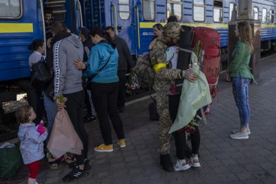 Dos parejas se besan durante su reunión después de tres meses de separación relacionada con la guerra en la estación de tren de Kharkiv en el este de Ucrania, el viernes 27 de mayo de 2022. (AP Foto/Bernat Armangue)