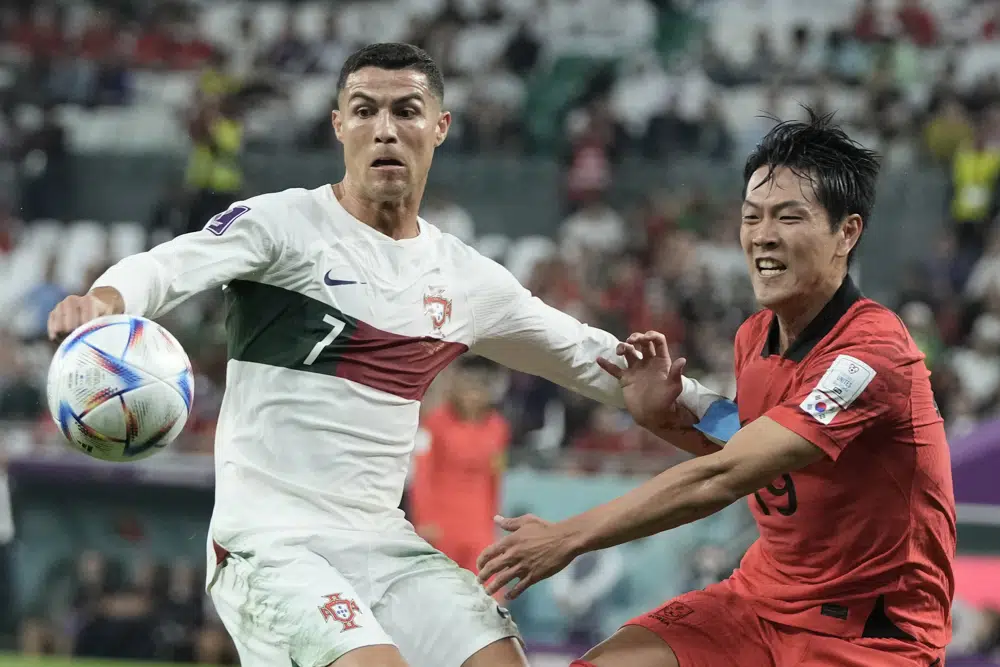 Cristiano Ronaldo de Portugal, a la izquierda, y Kim Young-gwon de Corea del Sur compiten por el balón durante el partido de fútbol del grupo H de la Copa Mundial entre Corea del Sur y Portugal, en el Education City Stadium en Al Rayyan, Qatar, el viernes 2 de diciembre de 2022. ( Foto AP/Hassan Ammar)