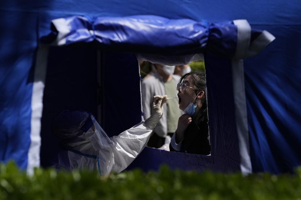 A resident gets tested outside an office building in the Haidian district on Tuesday, April 26, 2022, in Beijing. China's capital Beijing is enforcing mass testing and closing down access to neighborhoods as it seeks to contain a new COVID-19 outbreak. (AP Photo/Ng Han Guan)