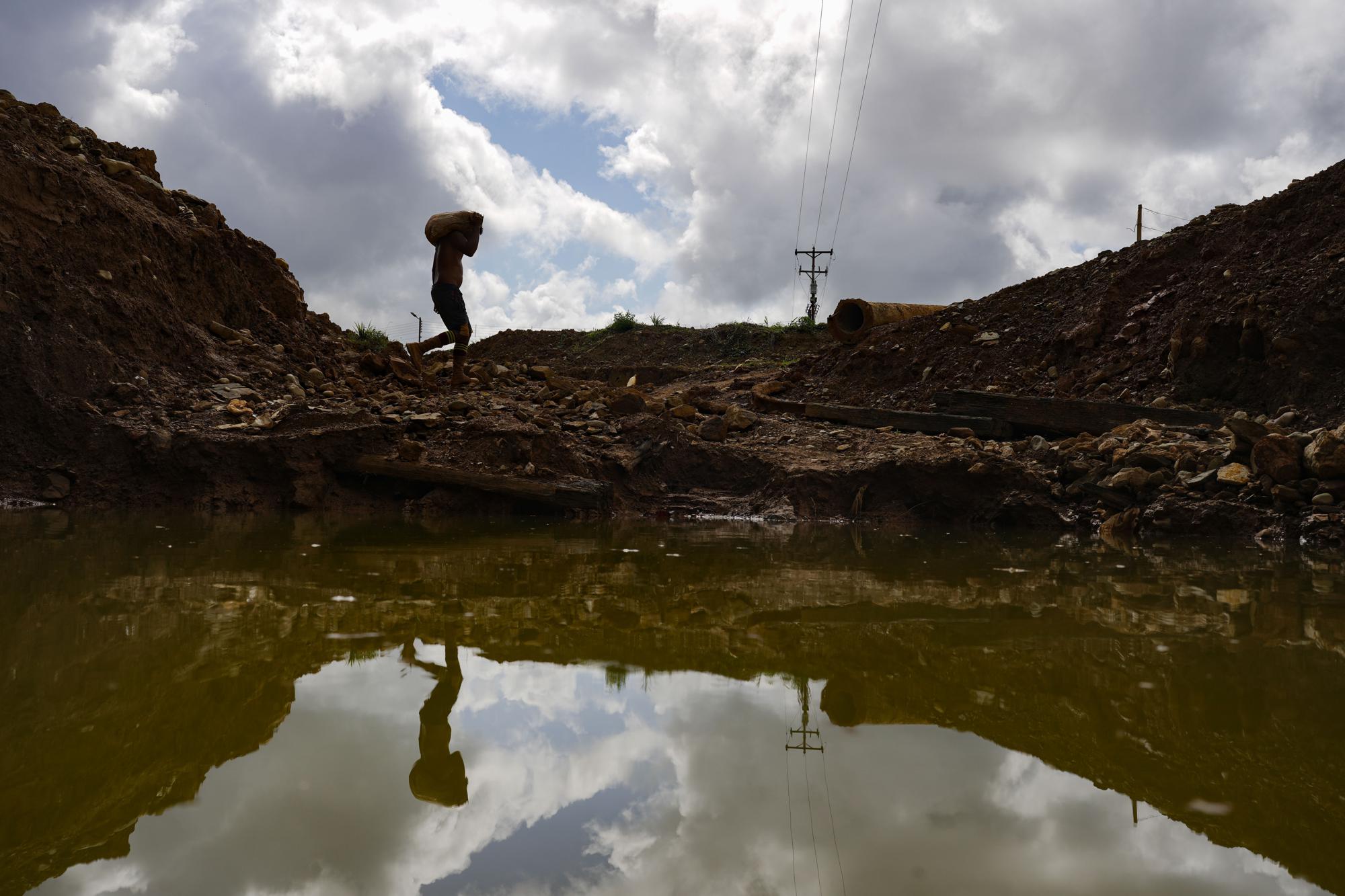 Un minero de oro lleva un saco de rocas a un molino en una mina en El Callao, estado de Bolívar, Venezuela, el sábado 29 de abril de 2023. (Foto AP/Matias Delacroix)