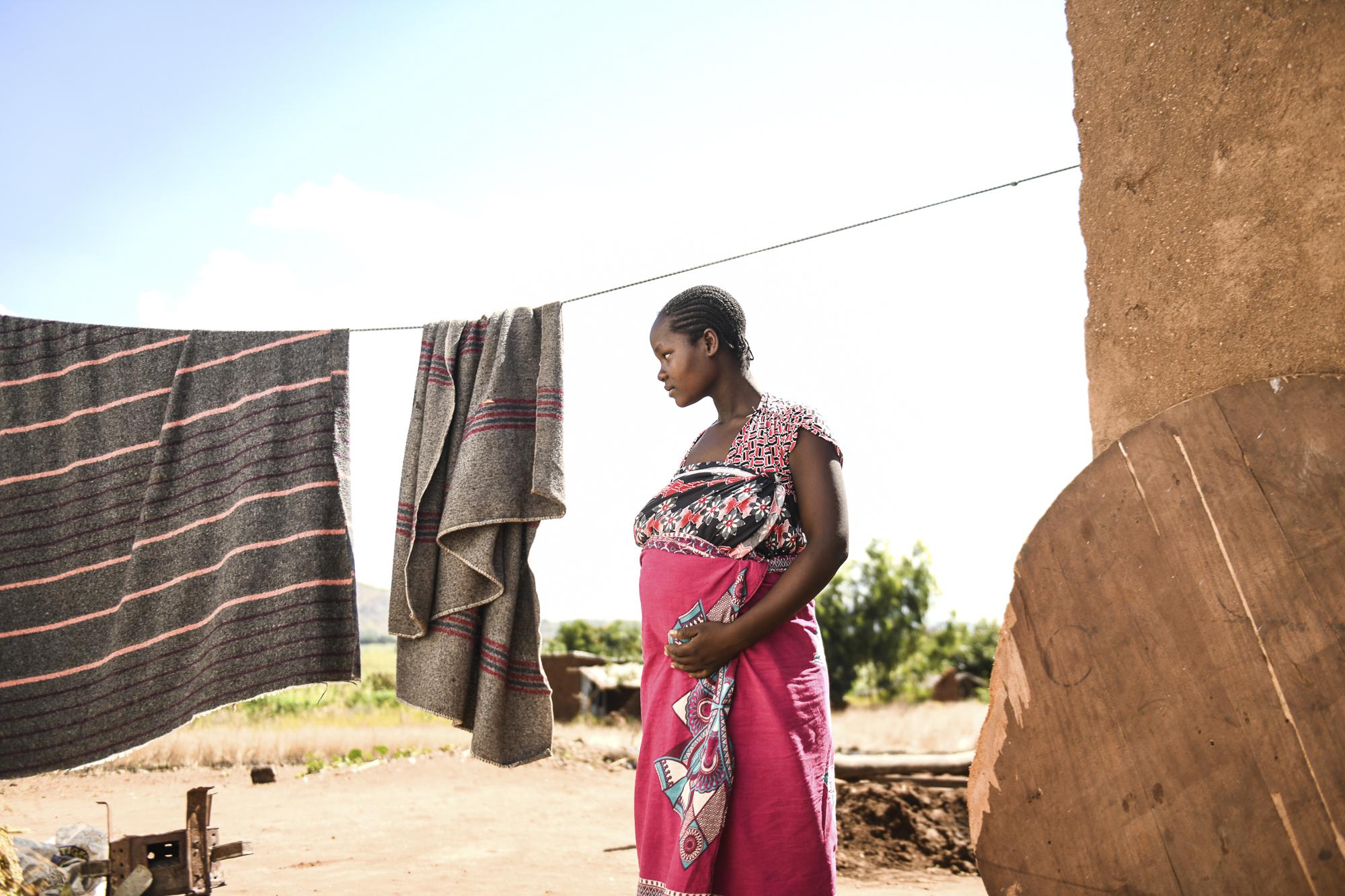 A pregnant woman waits to see Lucy Mbewe, a traditional birth attendant at her home in Simika Village, Chiradzulu, southern Malawi, Sunday, May 23, 2021. Health officials in Malawi say fewer women are getting prenatal care amid the COVID-19 pandemic. At risk are the developing country's gains on its poor rate of maternal deaths. (AP Photo/Thoko Chikondi)