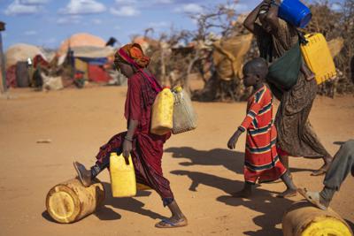 En esta imagen de archivo, una mujer y una niña llevan agua en un campo para desplazados, a las afueras de Dollow, Somalia, el 20 de septiembre de 2022. (AP Foto/Jerome Delay, archivo)