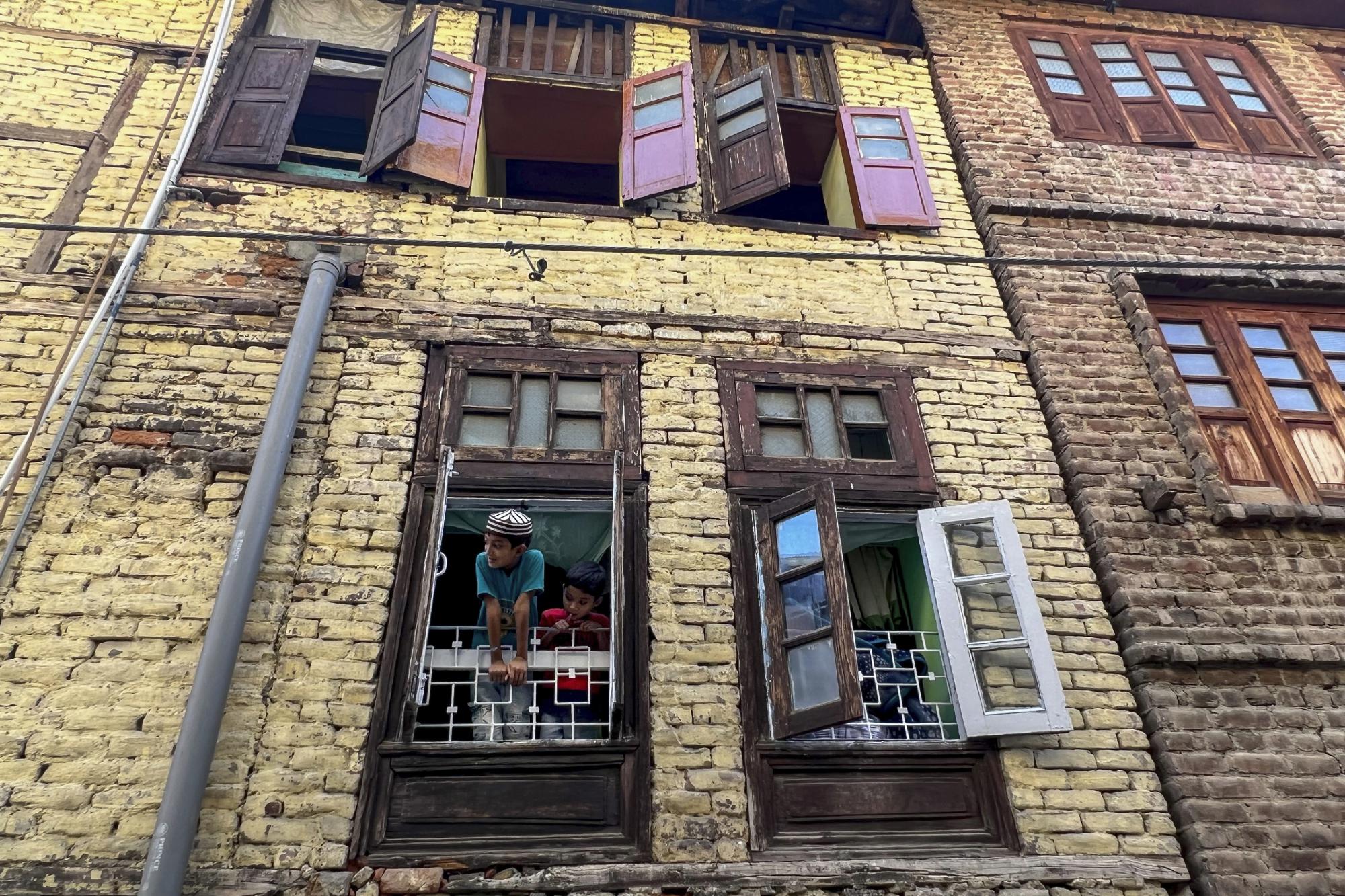 Tanzeel Ahmed, a la izquierda, y Umar Ahmed, hijos de trabajadores migrantes del estado de Uttar Pradesh, miran desde la ventana de su casa alquilada en Srinagar, Cachemira controlada por la India, en esta foto de iPhone del martes 14 de junio de 2022.  "Las fotos que ahora se toman con los últimos teléfonos se sienten más como arte digital que fotografías. Lo que ves a simple vista no es lo que ves en la pantalla. Y eso para mí es muy inquietante", escribió Yasin.  (Foto AP/Dar Yasin)