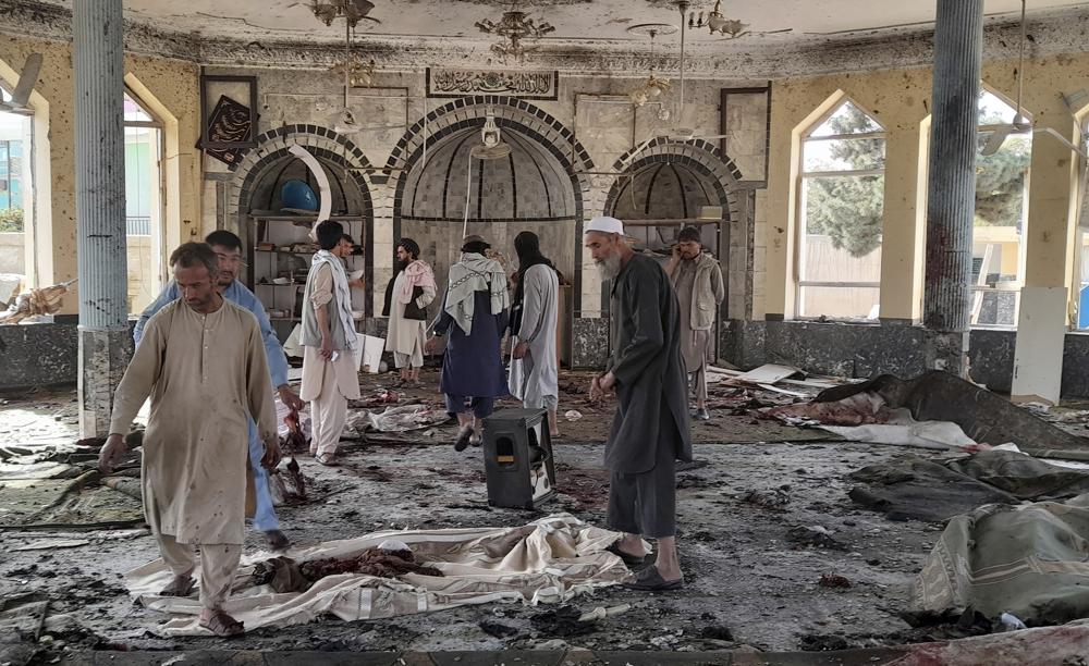 People view the damage inside of a mosque following a bombing in Kunduz, province northern Afghanistan, Friday, Oct. 8, 2021. A powerful explosion in the mosque frequented by a Muslim religious minority in northern Afghanistan on Friday has left several casualties, witnesses and the Taliban's spokesman said. (AP Photo/Abdullah Sahil)