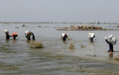 En esta imagen de archivo, víctimas de las graves inundaciones causadas por el monzón llevan ayuda a hombros en medio de la crecida, en el distrito de Qambar Shahdadkot, en la provincia de Sindh, Pakistán, el 9 de septiembre de 2022. (AP Foto/Fareed Khan, archivo)