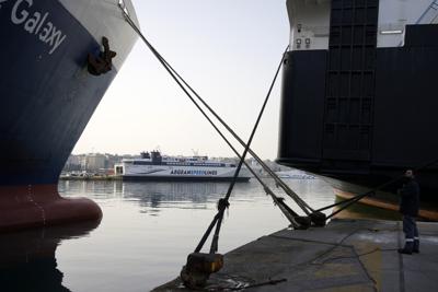 Un marinero de pie junto a transbordadores amarrados, durante una huelga de 24 horas en el puerto del Pireo, cerca de Atenas, Grecia, el miércoles 6 de abril de 2022. Los grandes sindicatos griego declararon la huelga contra un aumento de los precios debido a la guerra en Ucrania y pidieron subidas salariales y mejoras de los convenios colectivos. (AP Foto/Thanassis Stavrakis)