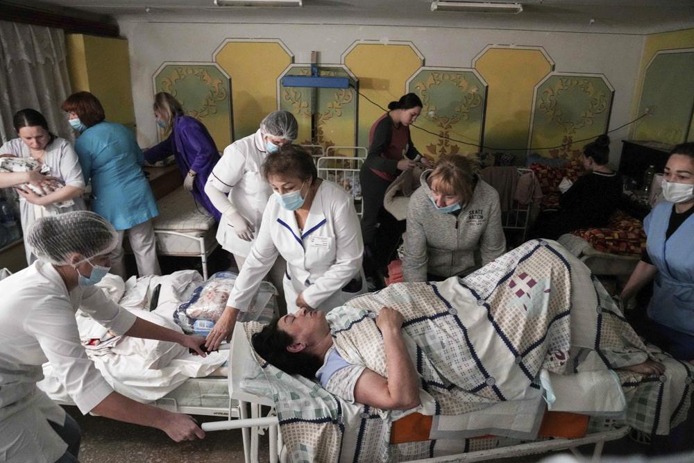 عمال طبيون ينقلون مريضة في قبو بمستشفى للولادة تم تحويله إلى جناح طبي واستخدامه كمأوى من القنابل في ماريوبول ، أوكرانيا ، الثلاثاء ، 1 مارس 2022. أدت الضربات الروسية على مدينة ماريوبول الساحلية الجنوبية إلى إصابة العديد من الأشخاص بجروح خطيرة.  (AP Photo / Evgeniy Maloletka)