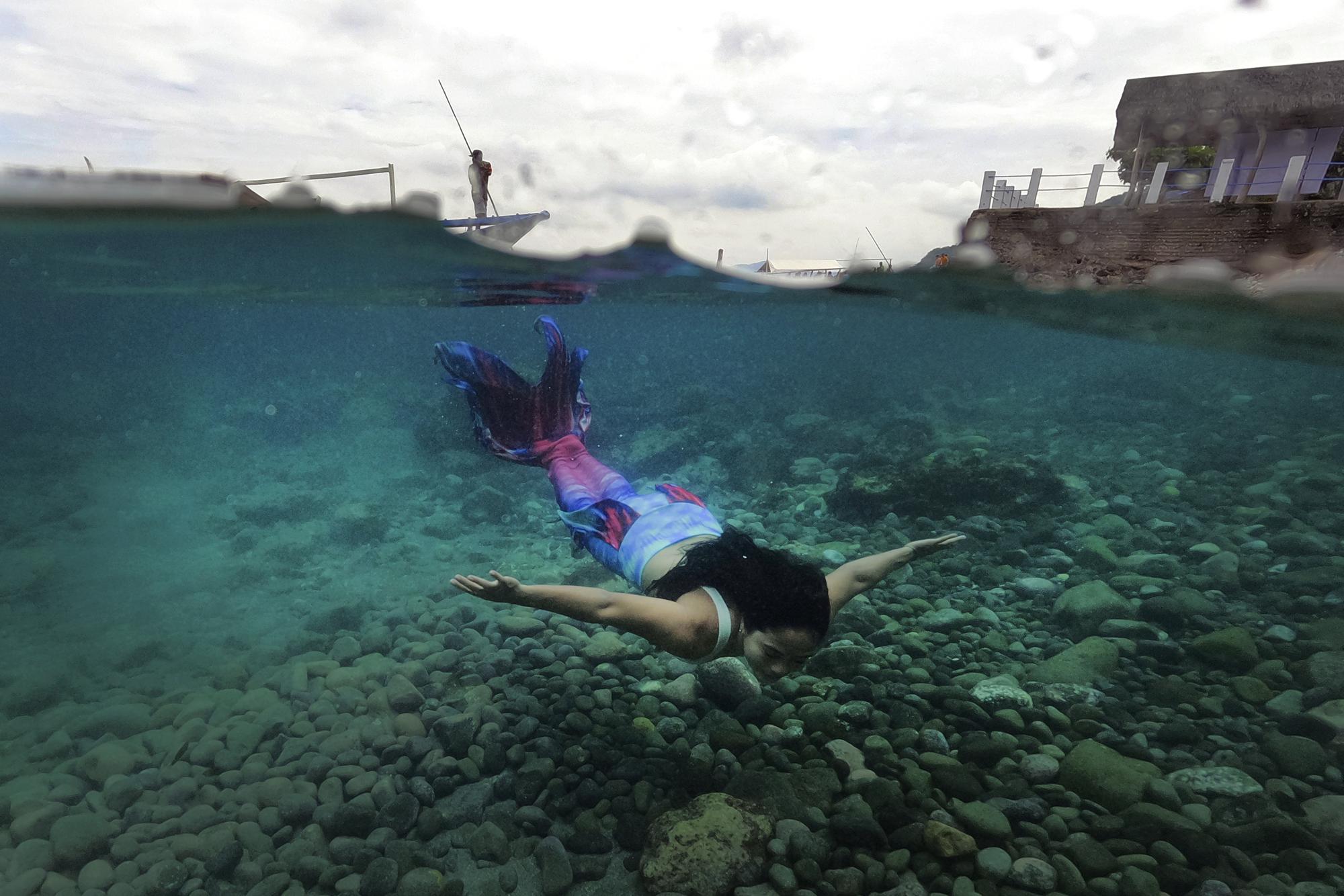 Filipina Jennica Secuya swims in her mermaid suit during a mermaiding class in Mabini, Batangas province, Philippines on Sunday, May 22, 2022. (AP Photo/Aaron Favila)