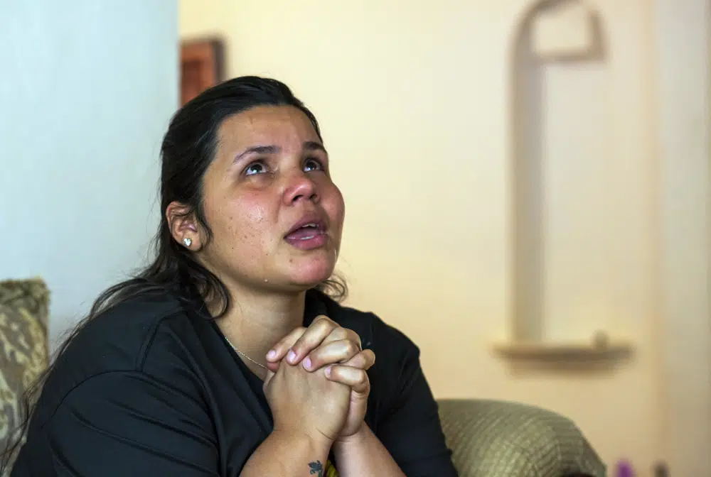 La solicitante de asilo venezolana Oriana Marcano lllora y da gracias a Dios por mantener a su familia a salvo durante el paso del Darién en Panamá, el año pasado, durante una entrevista con The Associated Press, en El Paso, Texas, el viernes 12 de mayo de 2023. (AP Foto/Andrés Leighton)
