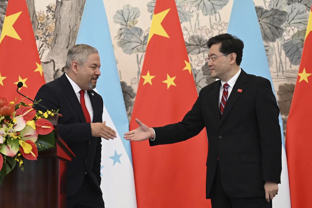 FILE - Honduran Foreign Minister Eduardo Enrique Reina Garcia, left, and Chinese Foreign Minister Qin Gang shake hands following the establishment of diplomatic relations between the two countries, during a joint statement after a ceremony in the Diaoyutai State Guesthouse in Beijing on Sunday, March 26, 2023. Heavily indebted Honduras cited “financial pressures” in its decision to establish formal diplomatic ties to China and sever those with Taiwan. (Greg Baker/Pool Photo via AP, File)