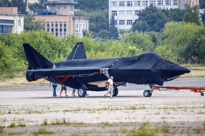 Hidden under tarpaulin, a prospective Russian fighter jet is being towed to a parking spot before its presentation at the Moscow international air show in Zhukovsky outside Moscow, Russia, Thursday, July 15, 2021. Russian aircraft makers say they will present a prospective new fighter jet at a Moscow air show that opens next week. The new warplane hidden under tarpaulin was photographed being towed to a parking spot across the airfield in Zhukovsky outside Moscow. That's where MAKS-2021 International Aviation and Space Salon opens on Tuesday. Russian President Vladimir Putin is set to visit the show’s opening. (AP Photo/Ivan Novikov-Dvinsky)
