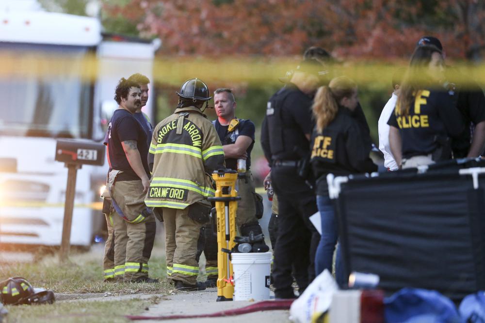Broken Arrow, Okla., police and fire department investigate the scene of a fire with multiple fatalities at the corner South Hickory Ave. and West Galveston St. on Thursday, Oct. 27, 2022. Eight people were found dead Thursday after a fire was extinguished at a Tulsa-area house, and police said they were investigating the deaths as homicides. (Ian Maule/Tulsa World via AP)