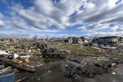 Decenas de construcciones arrasadas o dañadas tras el paso de un tornado nocturno en Sullivan, Indiana, el sábado 1 de abril de 2023. Se reportaron múltiples muertes en la zona después de la tormenta. (AP Foto/Doug McSchooler)