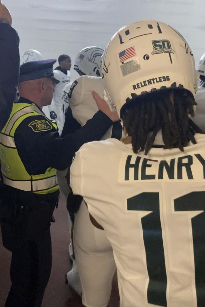 Security and police break up a scuffle between players from Michigan and Michigan State football teams in the Michigan Stadium tunnel after an NCAA college football game on Saturday, Oct. 29, 2022 in Ann Arbor, Mich. Michigan State President Samuel Stanley has apologized and says the actions of the football players who were involved in a postgame melee with Michigan players are “unacceptable.” He also says the players involved would be held responsible by coach Mel Tucker. (Kyle Austin/MLive Media Group via AP)