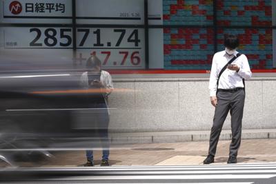 Una persona frente una cartelera financiera en Tokio el 26 de mayo del 2021. (Foto AP/Eugene Hoshiko)