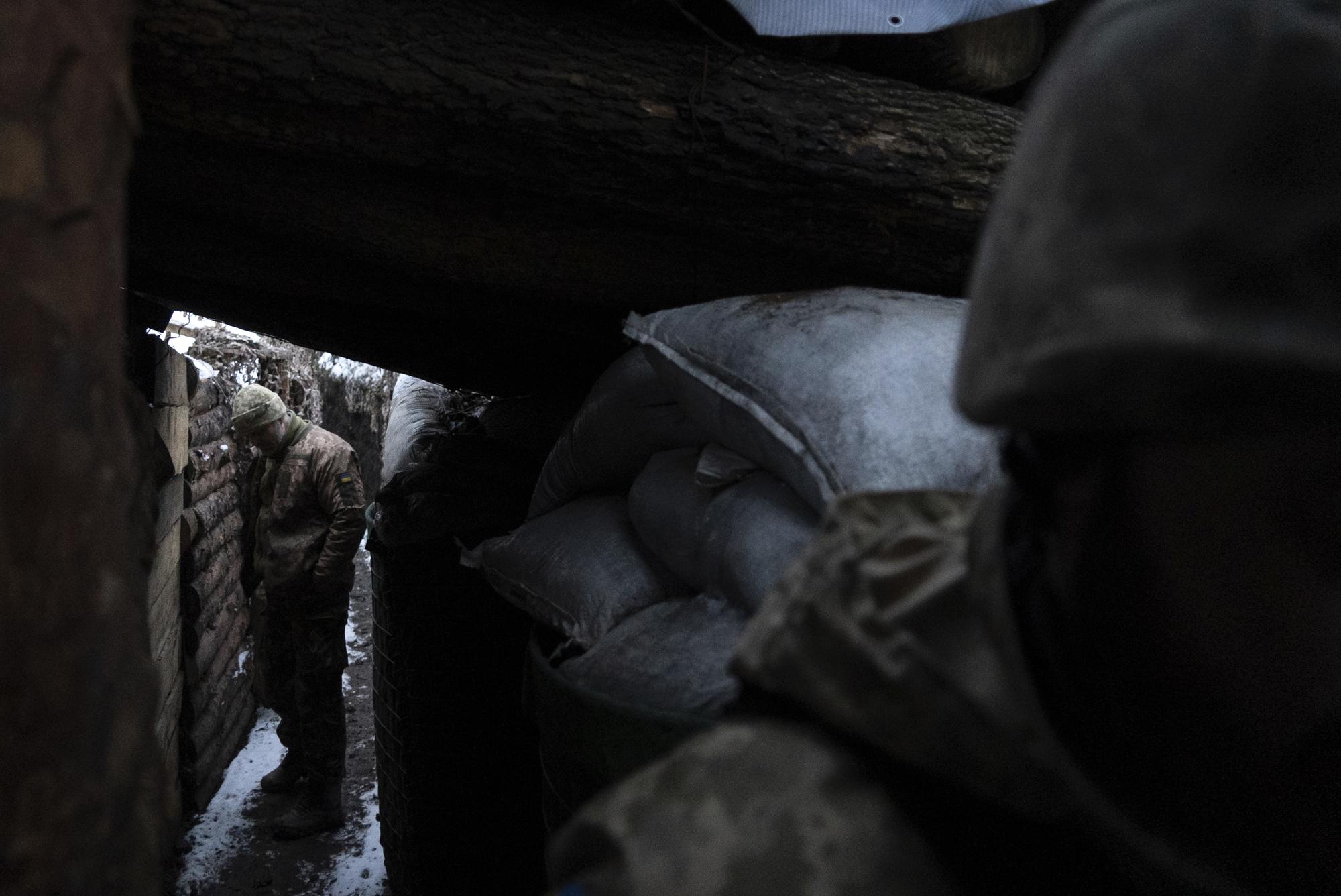 Ukrainian servicemen stand in a shelter listening to the sound of shelling at the frontline positions near Zolote, Ukraine, Feb. 7, 2022. (AP Photo/Mstyslav Chernov)